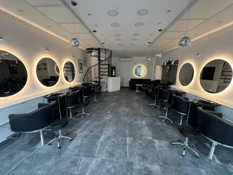 Heller Salonraum mit Wendeltreppe, Spiegelplätzen und Lounge bei IsarBella Hair & Beauty im Lehel